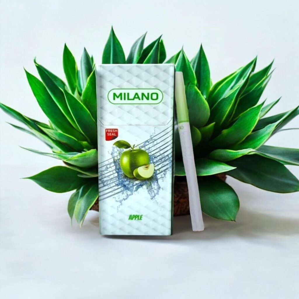 ซองบุหรี่ Milano Menthol สีขาวดีไซน์ทันสมัยพร้อมลวดลายสีเขียวมิ้นต์ วางบนพื้นโต๊ะไม้ท่ามกลางบรรยากาศธรรมชาติที่ผ่อนคลาย