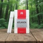 บุหรี่ Atlanta Red Premium ซองสีขาวแดง แถบเงินหรูหรา วางบนโต๊ะไม้ฉากหลังป่าสีเขียว