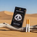 บุหรี่ Oris Panda (CN) ซองสีดำลายแพนด้าแบบพิกเซล วางบนขอนไม้กลางทะเลทราย พร้อมมวนบุหรี่ Nano Slim
