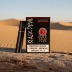 ซองบุหรี่ Black Devil Special Flavour สีดำดุดัน พร้อมมวนบุหรี่สีดำขอบทอง วางบนขอนไม้ท่ามกลางทรายสีทอง