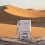 ซองบุหรี่ Davidoff White Super Slims สีขาวมุก ดีไซน์เรียบหรู วางเด่นบนขอนไม้กลางทะเลทราย